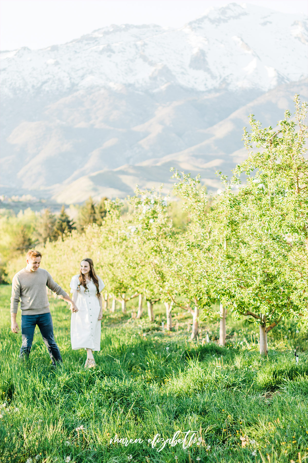 Spring engagement pictures at Burgess Orchards in Alpine, UT with a perfect view of the mountains. | Maren Elizabeth Photography