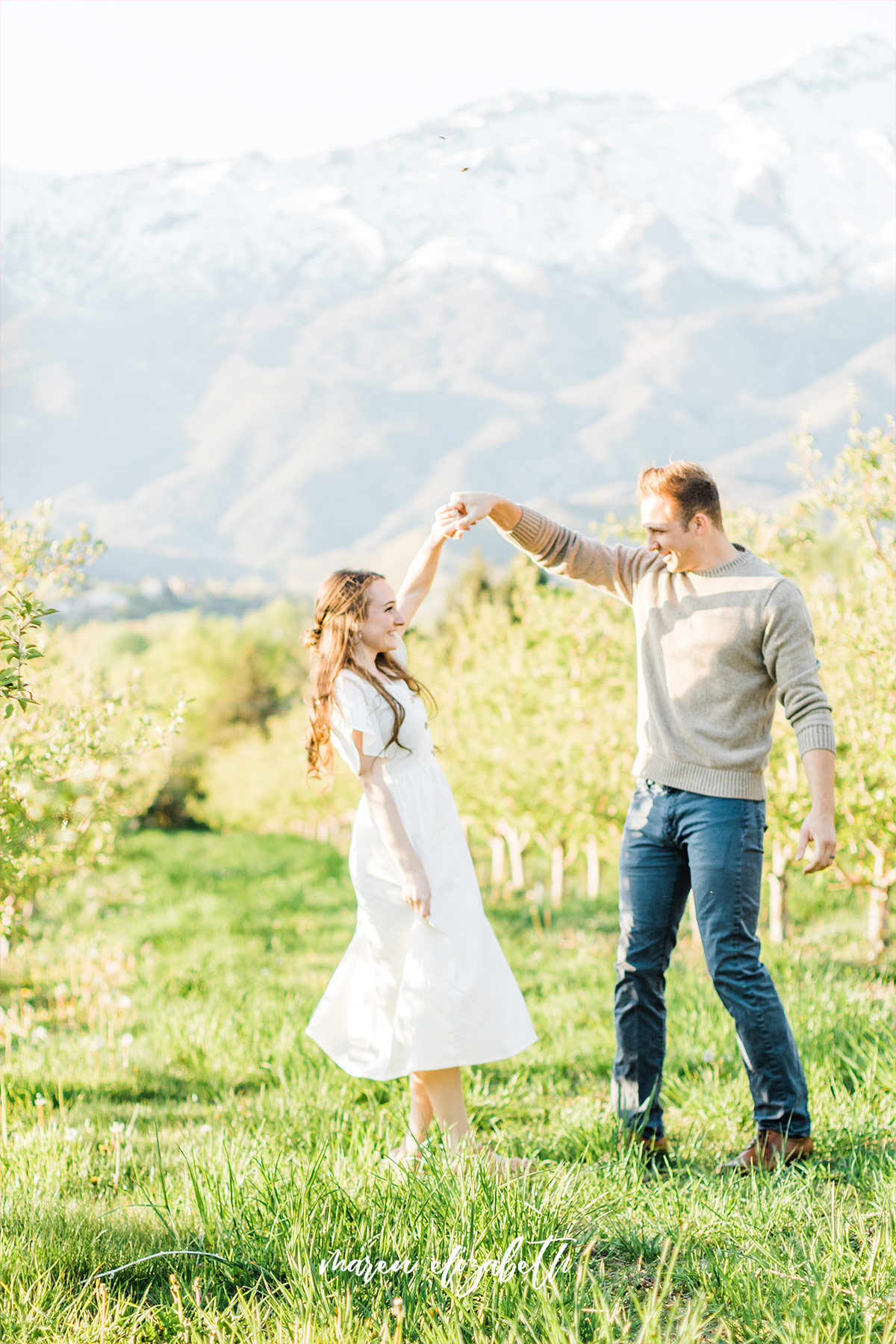 Spring engagement pictures at Burgess Orchards in Alpine, UT with a perfect view of the mountains. | Maren Elizabeth Photography